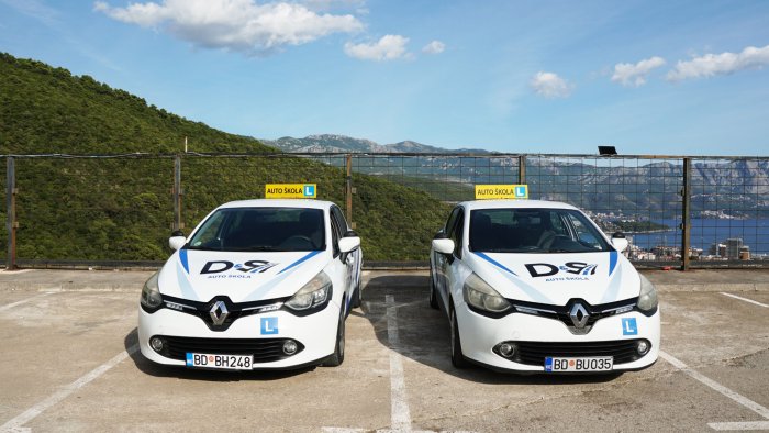 Dva Renault Clio vozila Auto-škole D&S sa L oznakom na parkingu iznad Budve
